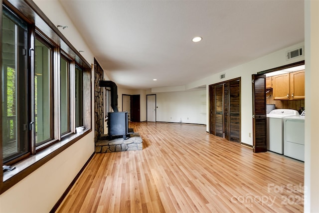 362 Cowan Valley Ests, Sylva, NC 28779 - unfurnished living room with washing machine and clothes dryer, a wood stove, light wood-style flooring, recessed lighting, and baseboards