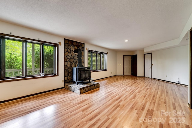 362 Cowan Valley Ests, Sylva, NC 28779 - unfurnished living room with a wood stove, baseboards, a textured ceiling, light wood-type flooring, and recessed lighting