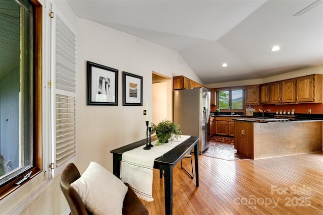 362 Cowan Valley Ests, Sylva, NC 28779 - kitchen with stainless steel fridge with ice dispenser, dark countertops, vaulted ceiling, brown cabinets, and a peninsula