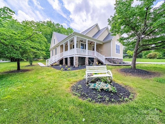 rear view of property featuring stairway, a porch, a yard, and a ceiling fan