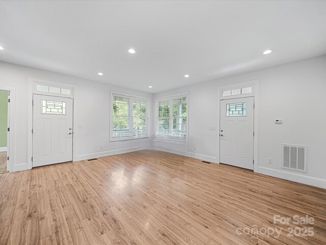foyer with light wood-style flooring, plenty of natural light, baseboards, and recessed lighting