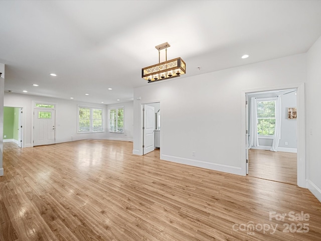 unfurnished living room with light wood-style flooring, baseboards, and recessed lighting
