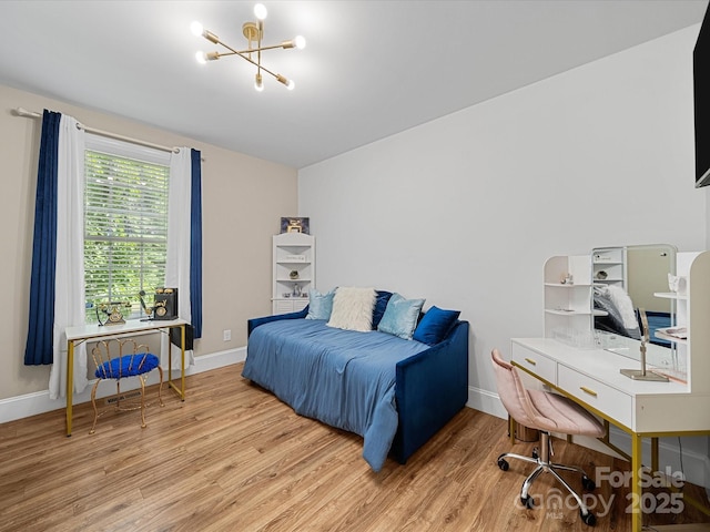 bedroom with wood finished floors, a desk, a chandelier, and baseboards