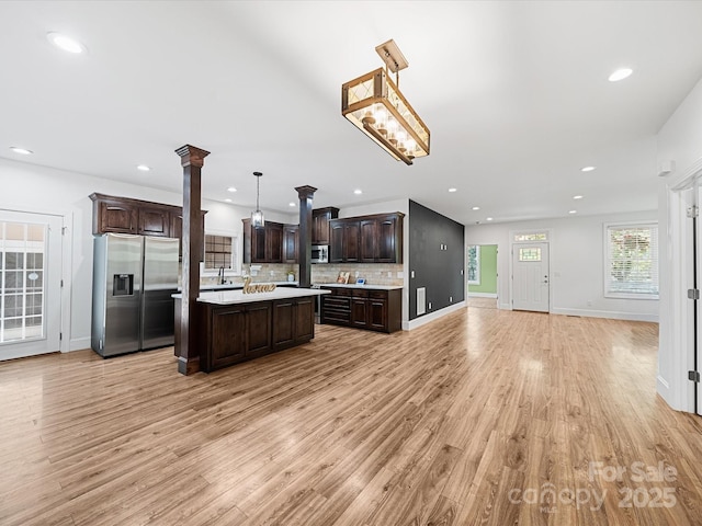 kitchen featuring appliances with stainless steel finishes, open floor plan, light countertops, dark brown cabinetry, and recessed lighting