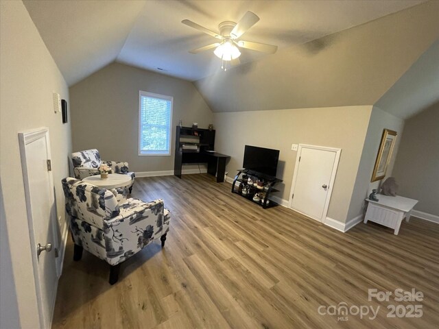 additional living space featuring lofted ceiling, wood finished floors, a ceiling fan, and baseboards