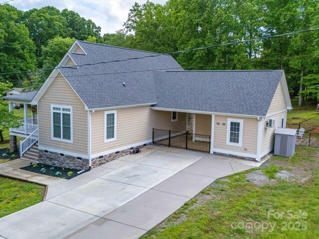 view of front of home featuring a shingled roof, a gate, covered porch, crawl space, and fence