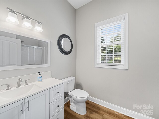 bathroom with wood finished floors, vanity, baseboards, and toilet
