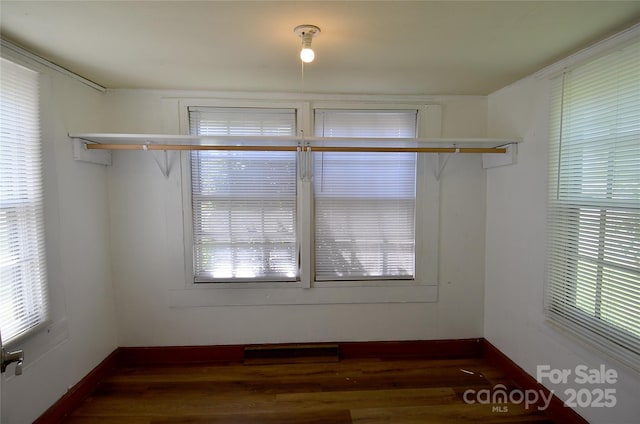 interior space with a wealth of natural light, wood finished floors, and baseboards