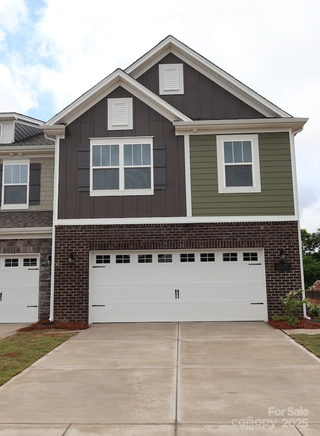 1119 Overbrook Pl, Wingate, NC 28174 - view of front of house with board and batten siding, an attached garage, concrete driveway, and brick siding