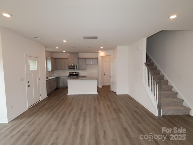 1119 Overbrook Pl, Wingate, NC 28174 - unfurnished living room featuring wood finished floors, stairs, baseboards, and recessed lighting