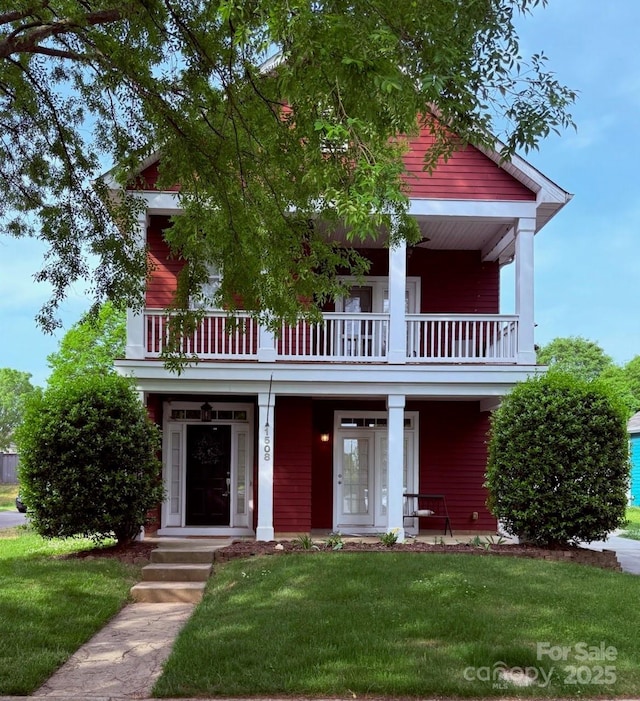 view of front of house featuring a front yard, a porch, and a balcony