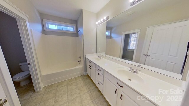 bathroom featuring plenty of natural light, a sink, and toilet