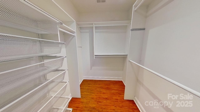 walk in closet featuring visible vents and wood finished floors