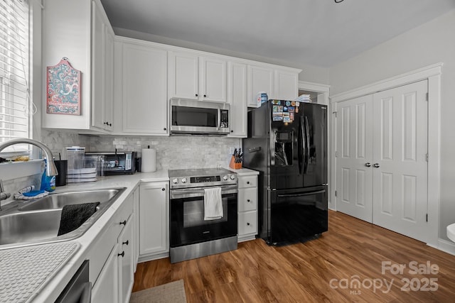 1508 Peaceful Way Dr, Charlotte, NC 28206 - kitchen featuring appliances with stainless steel finishes, a sink, white cabinets, and backsplash