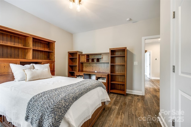 bedroom featuring baseboards and dark wood-style flooring