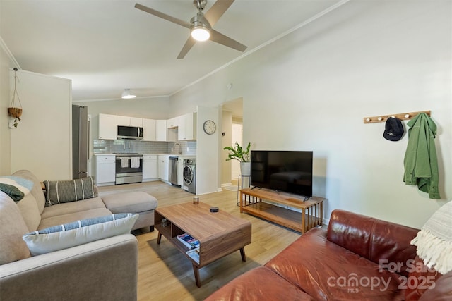 living room with vaulted ceiling, light wood-style flooring, a ceiling fan, and ornamental molding