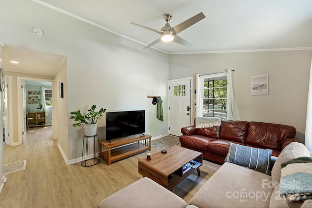 living area featuring light wood-type flooring, vaulted ceiling, baseboards, a ceiling fan, and ornamental molding