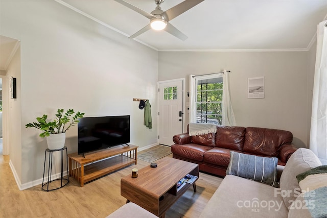 living area featuring light wood-style floors, crown molding, baseboards, and a ceiling fan