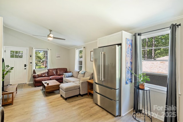 living area with plenty of natural light, light wood-style flooring, a ceiling fan, and crown molding