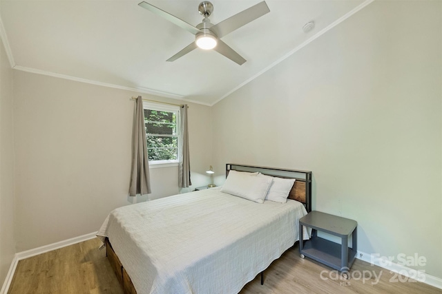 bedroom with vaulted ceiling, baseboards, a ceiling fan, wood finished floors, and ornamental molding