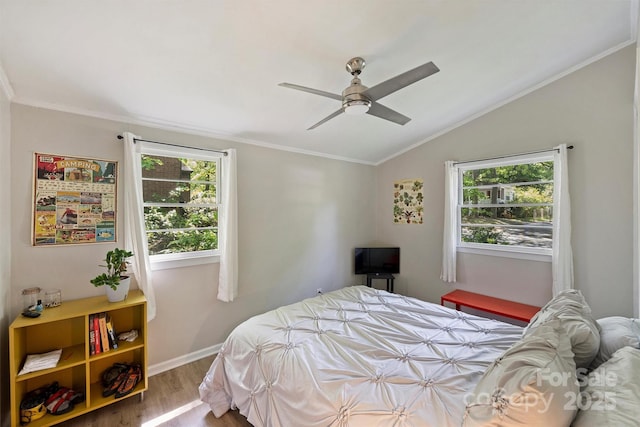 bedroom with wood finished floors, lofted ceiling, ornamental molding, and multiple windows