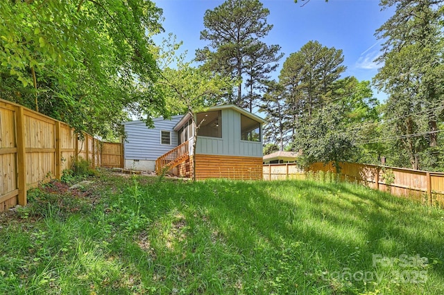 view of yard with a fenced backyard and entry steps