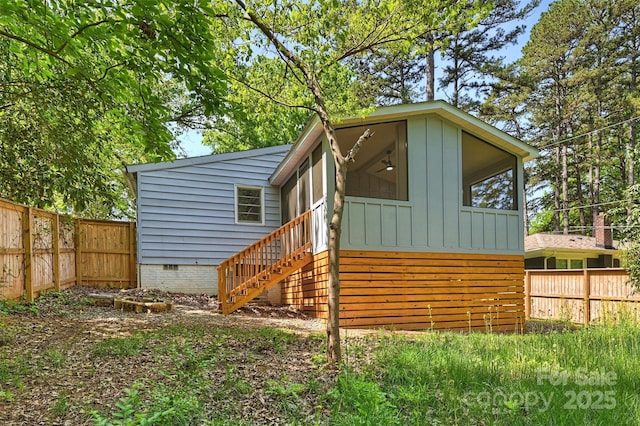 rear view of house with fence, crawl space, and stairs