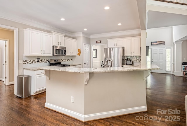 141 Culpeze Rd, Mooresville, NC 28117 - kitchen with appliances with stainless steel finishes, decorative backsplash, white cabinetry, a breakfast bar area, and ornamental molding
