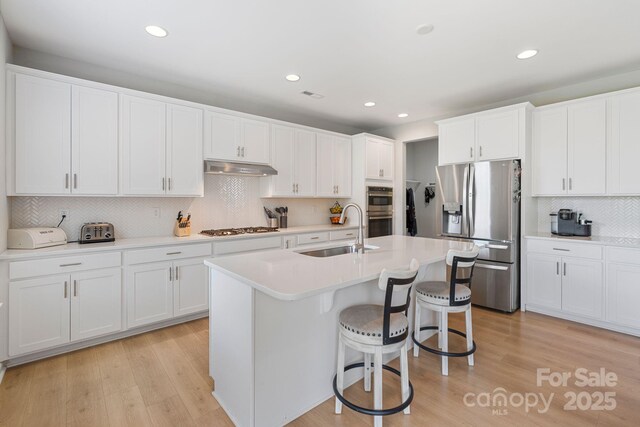 kitchen featuring recessed lighting, decorative backsplash, stainless steel appliances, and a sink