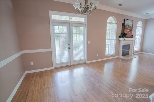 134 Walmsley Pl, Mooresville, NC 28117 - unfurnished living room with an inviting chandelier, a healthy amount of sunlight, light wood-type flooring, and ornamental molding
