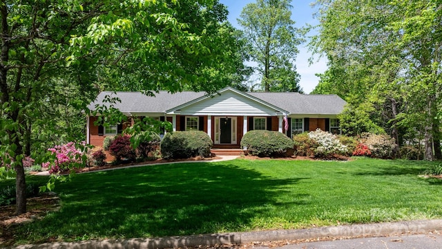 single story home featuring brick siding and a front yard
