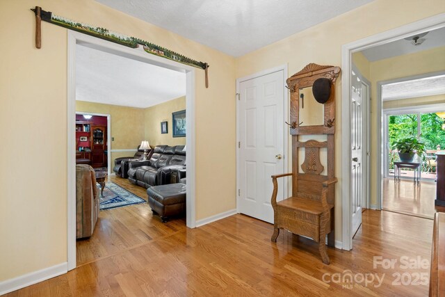 hallway featuring wood finished floors and baseboards