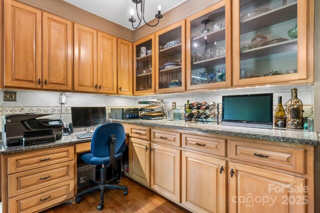 office space with built in desk and dark wood-style flooring