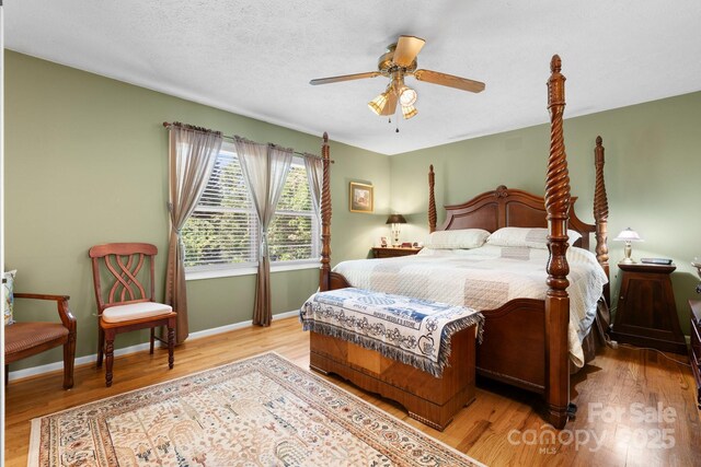 bedroom featuring baseboards, a ceiling fan, and wood finished floors