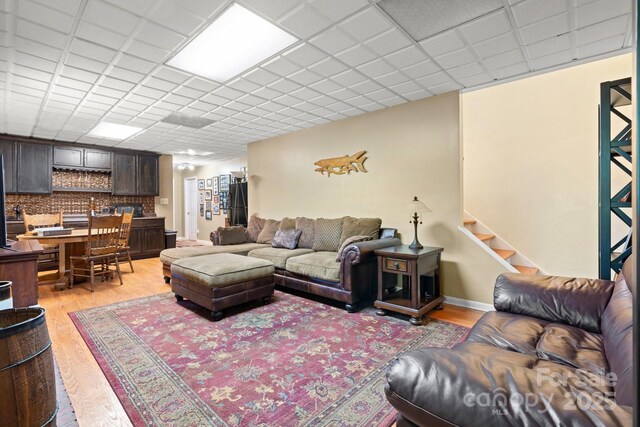 living room featuring light wood-style flooring and stairs