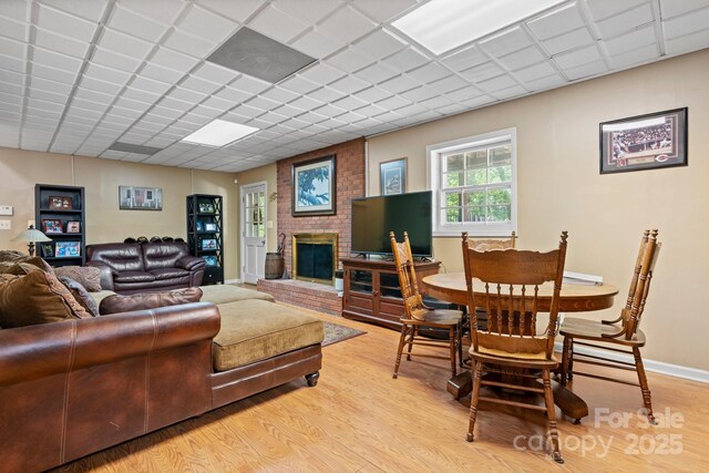living area with light wood-style floors and a brick fireplace
