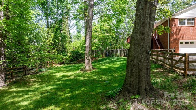 view of yard with a garage and a fenced backyard