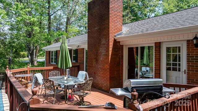 deck featuring a grill and outdoor dining space