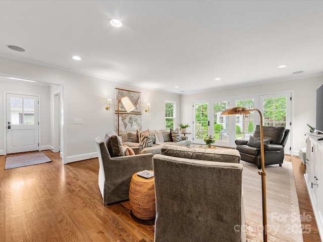 living area featuring a healthy amount of sunlight, light wood-type flooring, recessed lighting, and ornamental molding