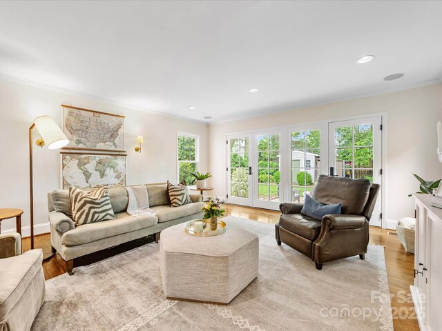 living area featuring recessed lighting, light wood-style flooring, french doors, and crown molding