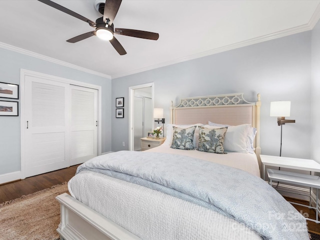 bedroom with a closet, a ceiling fan, baseboards, ornamental molding, and wood finished floors