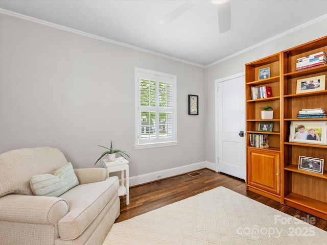 sitting room featuring dark wood-style floors, crown molding, a ceiling fan, visible vents, and baseboards