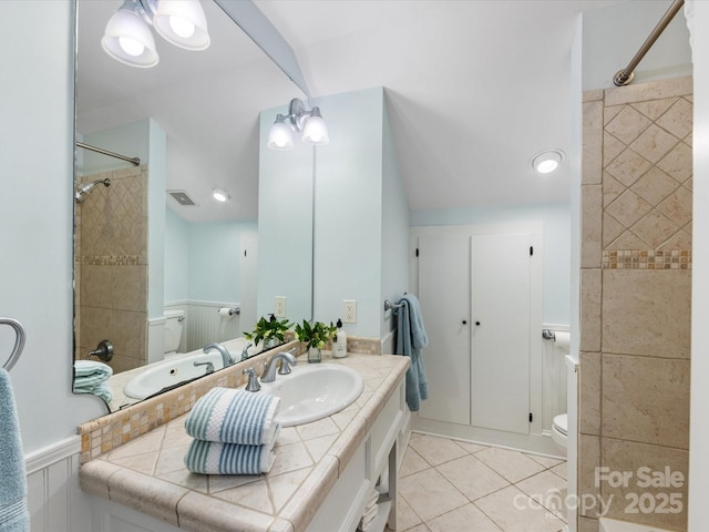 full bath with toilet, a wainscoted wall, visible vents, walk in shower, and tile patterned flooring