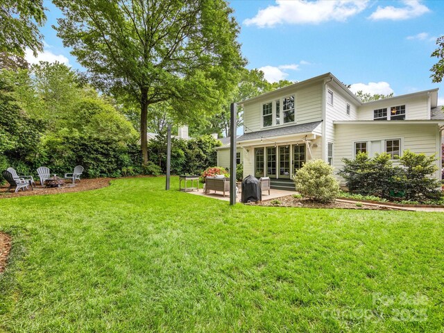 back of house with a fire pit, a patio area, and a yard
