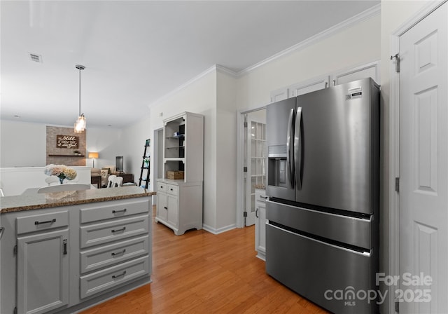kitchen featuring gray cabinets, stainless steel fridge with ice dispenser, light wood finished floors, decorative light fixtures, and ornamental molding