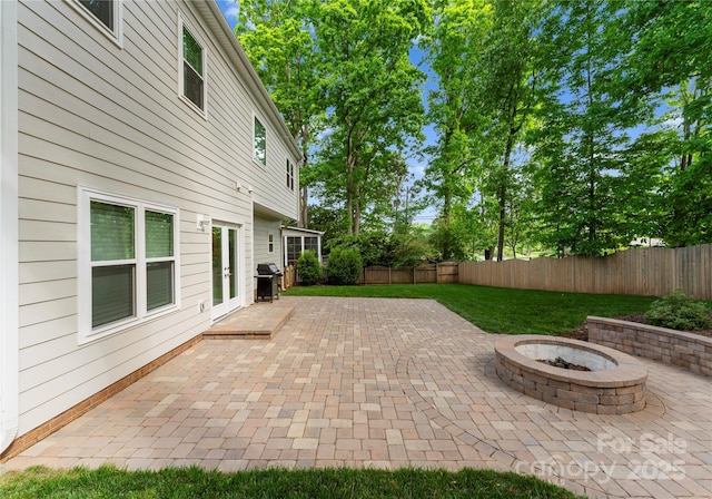 view of patio / terrace featuring area for grilling, a fire pit, a fenced backyard, and french doors