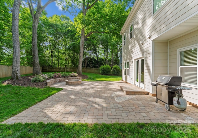 view of patio with a fenced backyard, an outdoor fire pit, french doors, and a grill