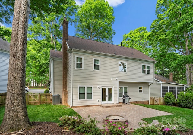 back of property with fence, french doors, a yard, and a patio