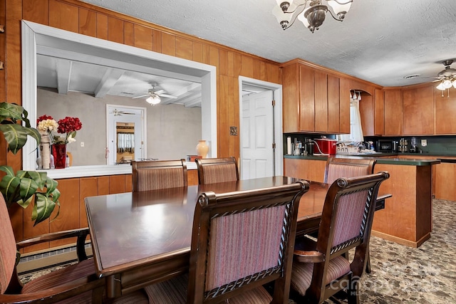 3265 W Innes St, Salisbury, NC 28144 - dining area with a ceiling fan, a baseboard heating unit, wooden walls, a chandelier, and a textured ceiling