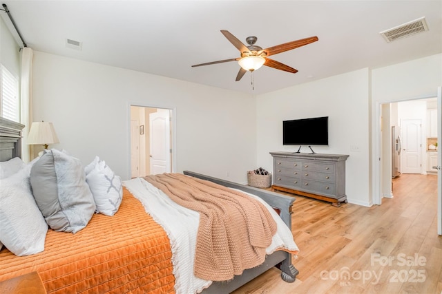 bedroom featuring light wood-style floors, visible vents, ceiling fan, and stainless steel fridge with ice dispenser